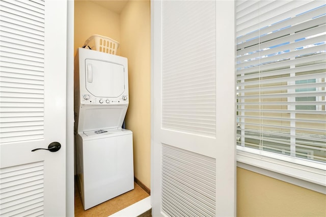 clothes washing area featuring stacked washing maching and dryer