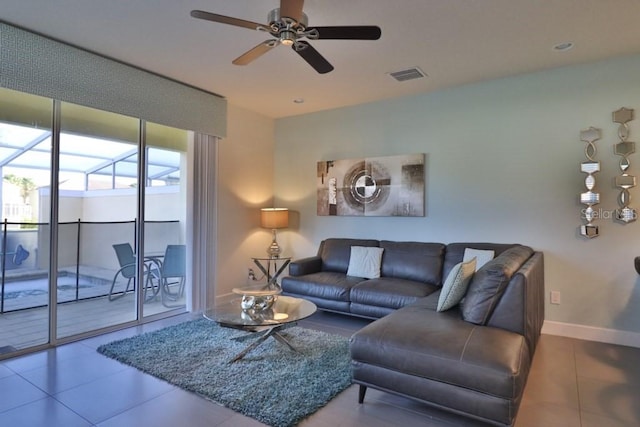 living area featuring ceiling fan, light tile patterned flooring, visible vents, and baseboards