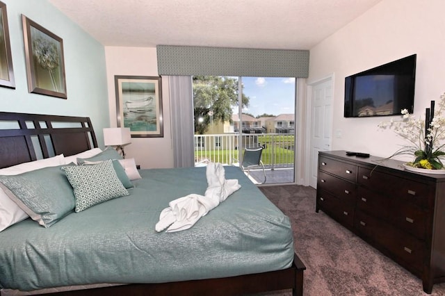 bedroom featuring access to outside, dark colored carpet, and a textured ceiling