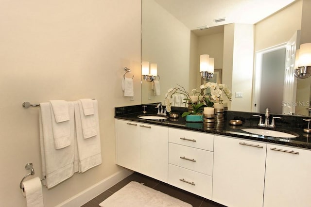 bathroom featuring double vanity, visible vents, baseboards, and a sink