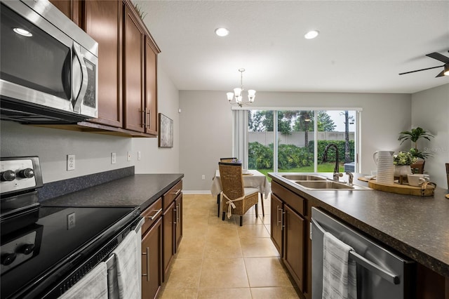 kitchen featuring appliances with stainless steel finishes, ceiling fan with notable chandelier, pendant lighting, sink, and light tile patterned floors