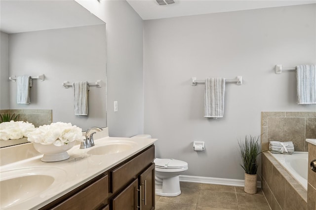 bathroom with vanity, tiled bath, tile patterned floors, and toilet