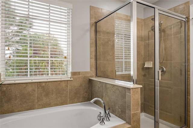 bathroom featuring independent shower and bath