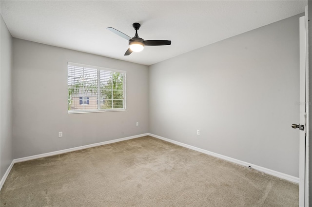 carpeted spare room featuring ceiling fan