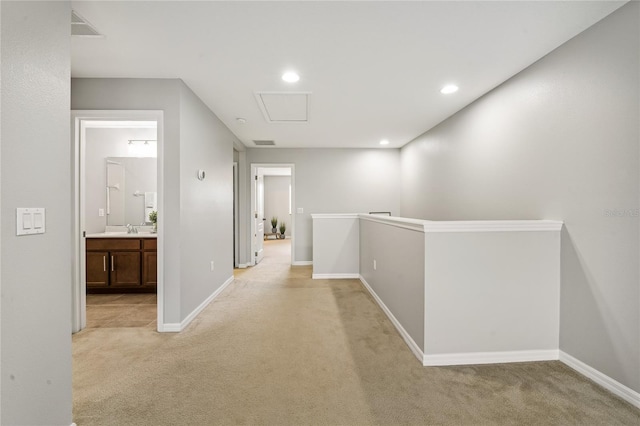 hallway featuring sink and light colored carpet