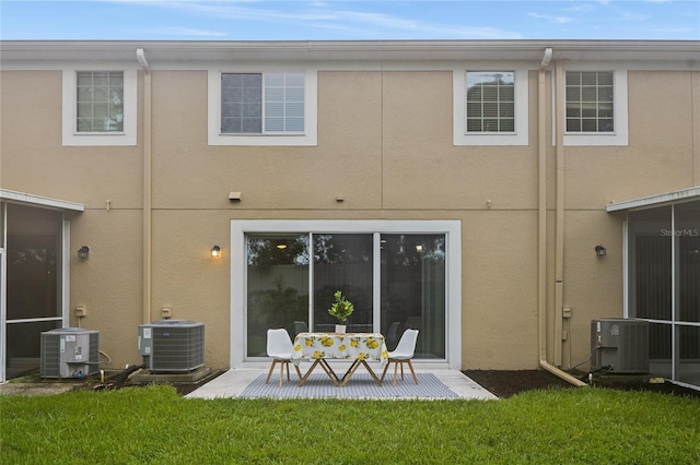 rear view of house featuring a yard and central AC