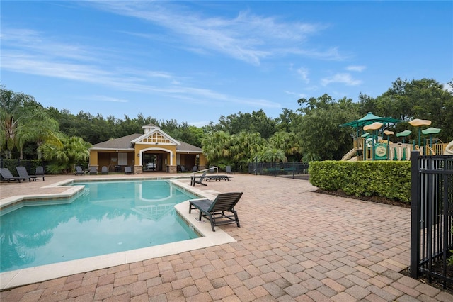 view of pool featuring a patio and a playground