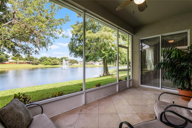 sunroom with a water view and ceiling fan