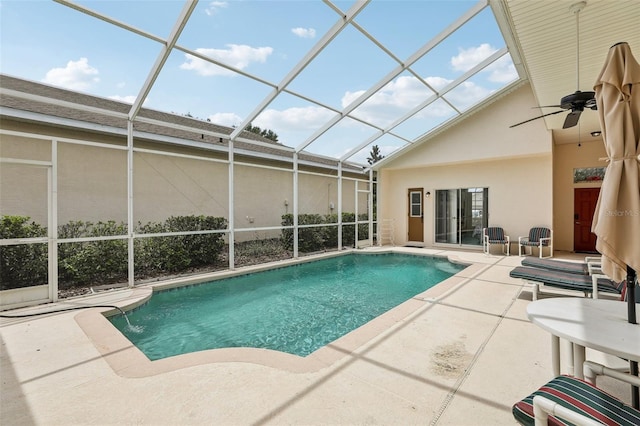 view of swimming pool featuring ceiling fan, glass enclosure, and a patio area