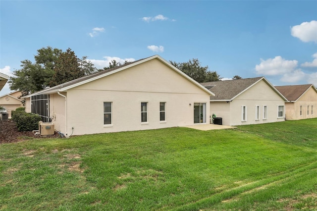 rear view of property with a yard, central AC, and a sunroom