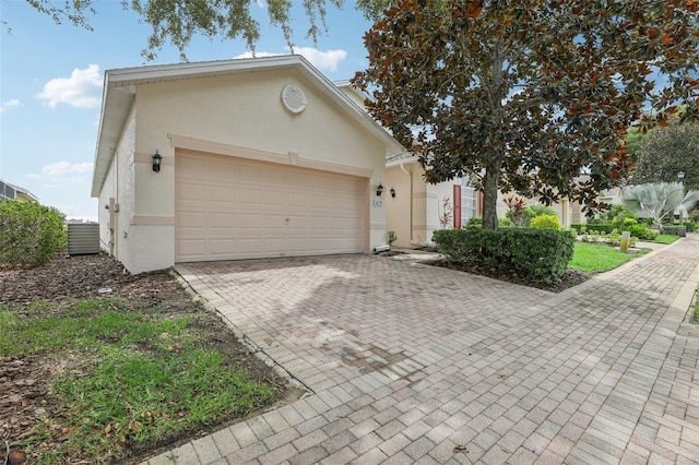 view of front of house featuring a garage, decorative driveway, and stucco siding