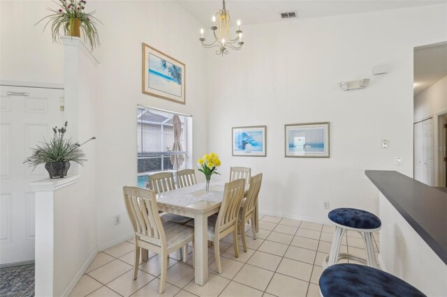 dining room with visible vents, a towering ceiling, an inviting chandelier, and light tile patterned flooring