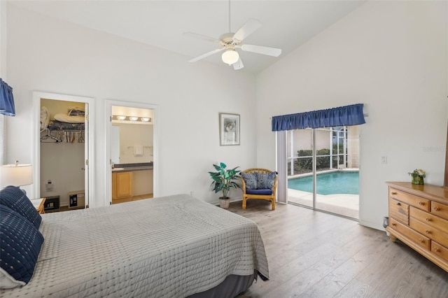 bedroom featuring access to exterior, a ceiling fan, connected bathroom, wood finished floors, and high vaulted ceiling