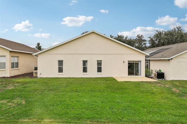 rear view of house with a yard, central air condition unit, a patio, and stucco siding