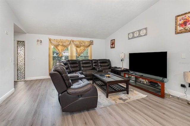 living room featuring lofted ceiling and light hardwood / wood-style flooring