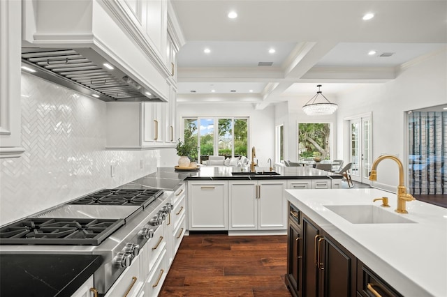 kitchen with sink, beamed ceiling, hanging light fixtures, and custom range hood