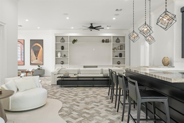 dining room with built in shelves, ceiling fan, and crown molding