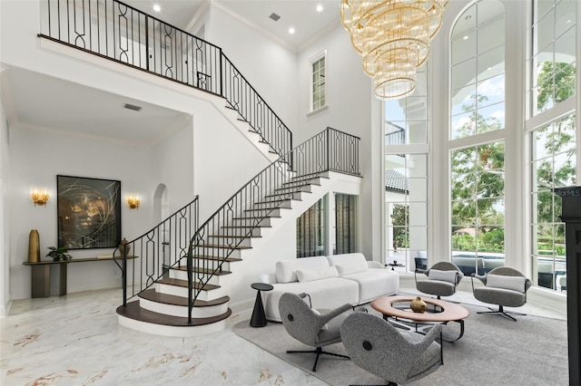 living room with ornamental molding, a high ceiling, and an inviting chandelier