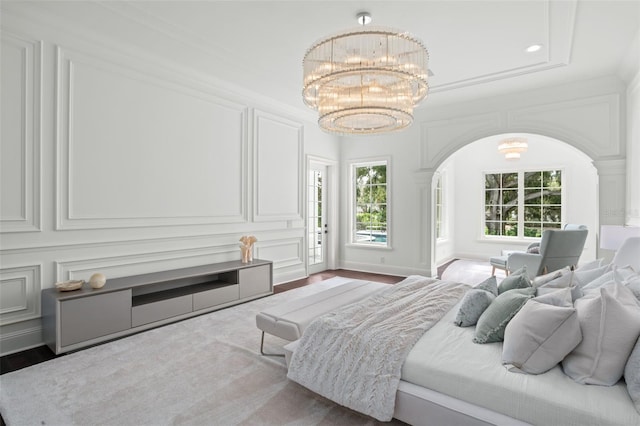 bedroom featuring a notable chandelier, wood-type flooring, and crown molding