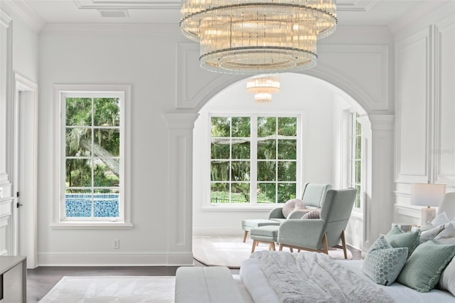 bedroom with multiple windows, crown molding, hardwood / wood-style floors, and a notable chandelier