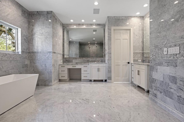 bathroom with a bathing tub, vanity, and tile walls