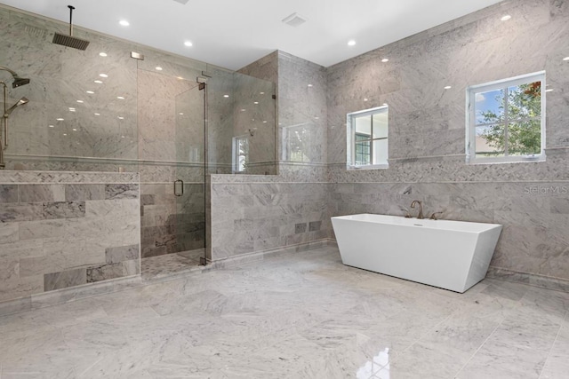 bathroom featuring plus walk in shower and tile walls