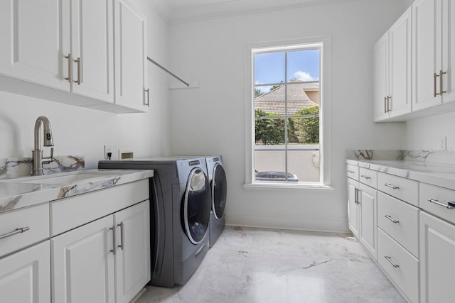 washroom featuring cabinets, washing machine and clothes dryer, ornamental molding, and sink