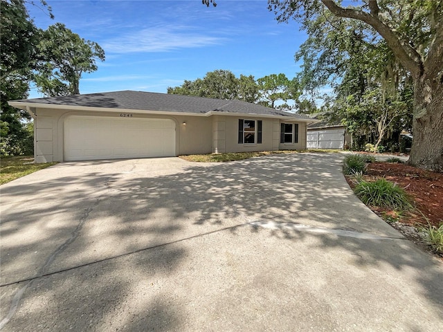 view of front facade with a garage, driveway, and stucco siding