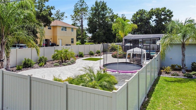 view of yard featuring a trampoline and a patio