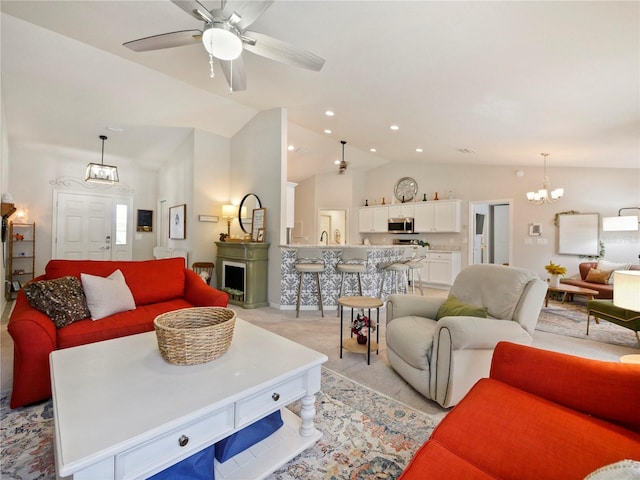 carpeted living room with lofted ceiling and ceiling fan with notable chandelier