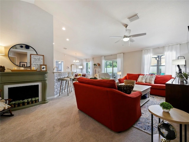 living room featuring light colored carpet, lofted ceiling, and ceiling fan with notable chandelier