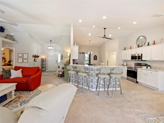 kitchen with white cabinetry, stainless steel appliances, a breakfast bar, and hanging light fixtures