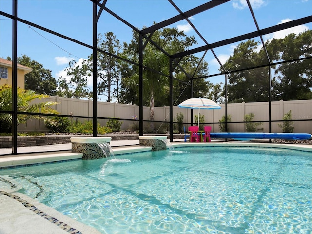 view of swimming pool featuring glass enclosure