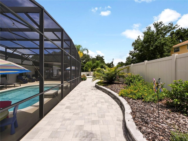 view of swimming pool with glass enclosure and a patio area