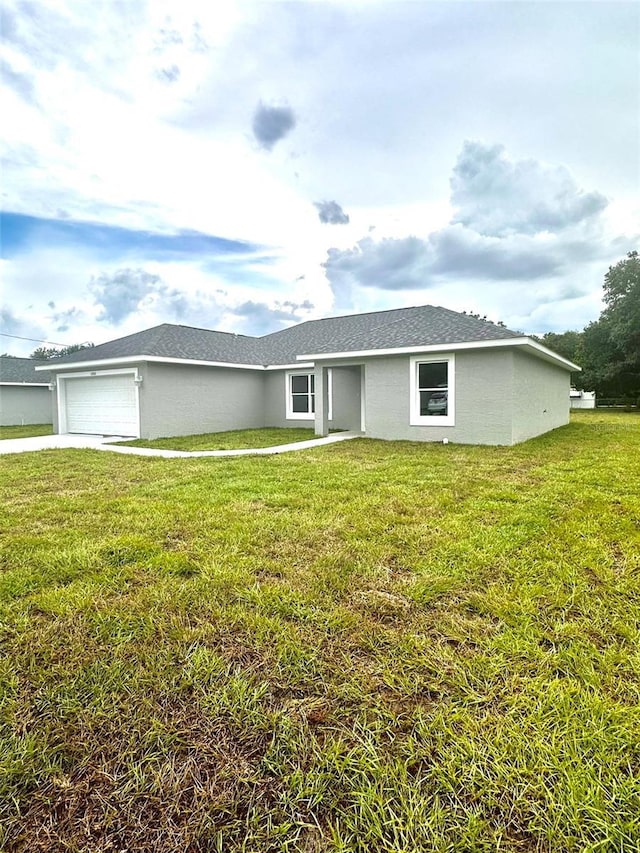 single story home featuring concrete driveway, a front lawn, an attached garage, and stucco siding