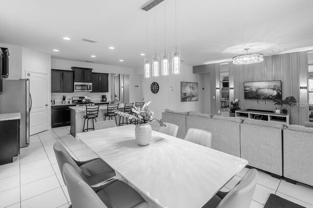 dining space featuring light tile patterned floors and a chandelier