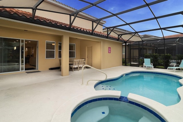 view of swimming pool featuring an in ground hot tub, glass enclosure, and a patio area