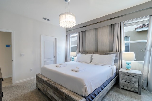 bedroom featuring carpet flooring and a chandelier