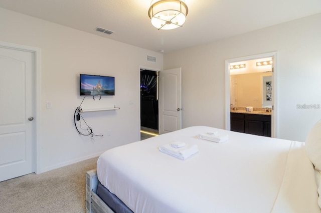 bedroom featuring light carpet and connected bathroom