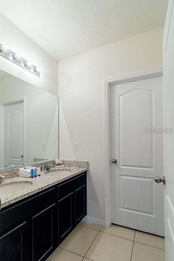 bathroom with vanity, a textured ceiling, and tile patterned floors