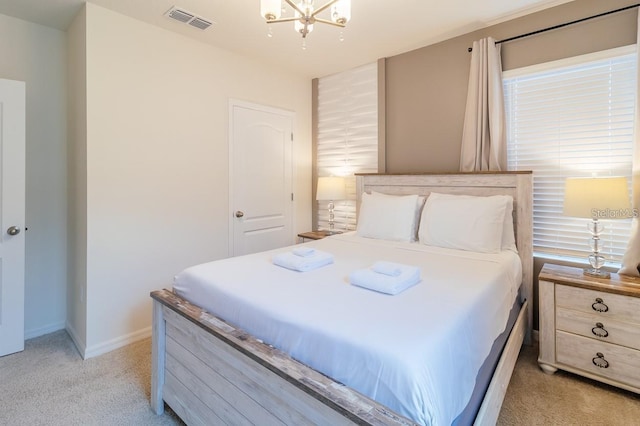 bedroom featuring a chandelier and light colored carpet