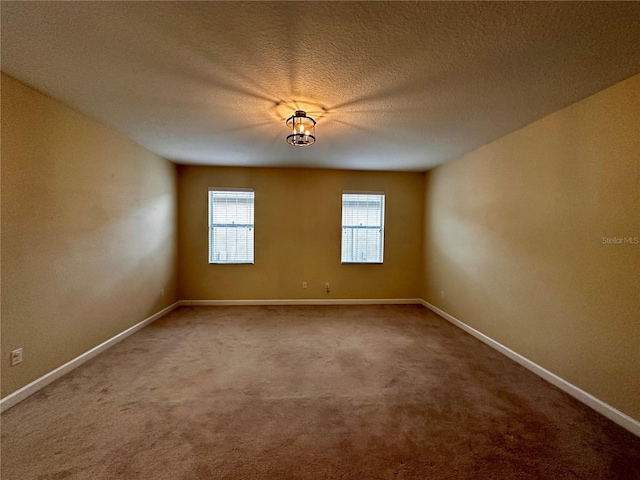 carpeted spare room featuring a textured ceiling