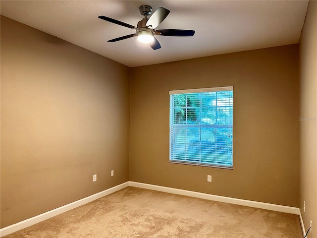 carpeted spare room with ceiling fan