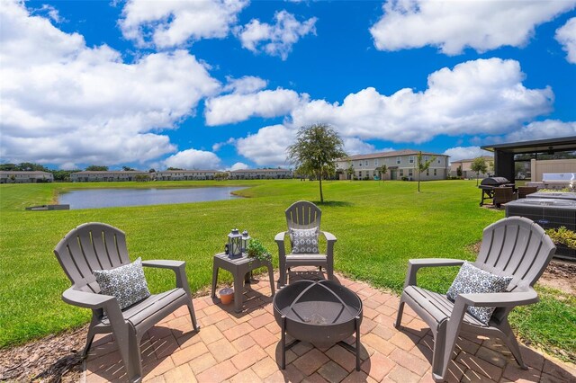 view of patio featuring grilling area, a water view, and a fire pit