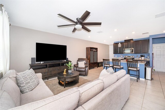 tiled living room with sink and ceiling fan