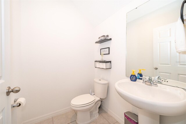 bathroom with sink, toilet, and tile patterned flooring