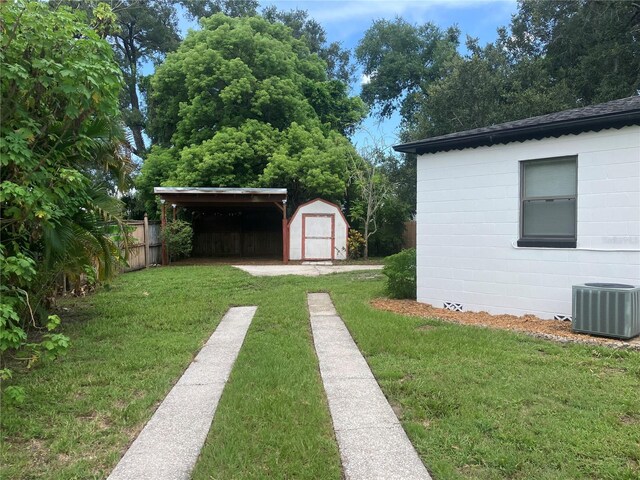 view of yard featuring central AC unit and a storage shed