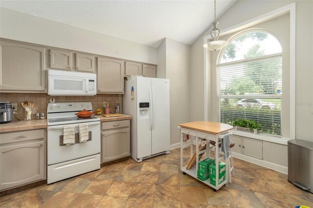 kitchen featuring decorative light fixtures, lofted ceiling, backsplash, a healthy amount of sunlight, and white appliances