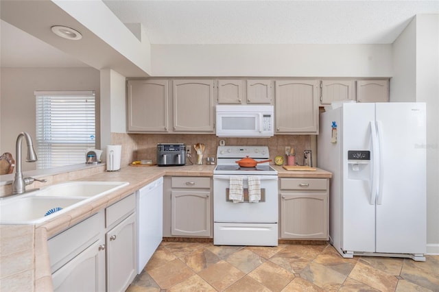 kitchen featuring tasteful backsplash, sink, white appliances, and a textured ceiling