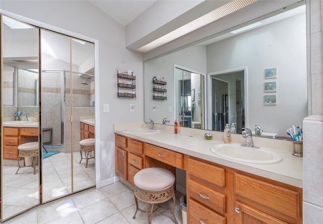 bathroom featuring tile patterned floors, vanity, and a shower with shower door